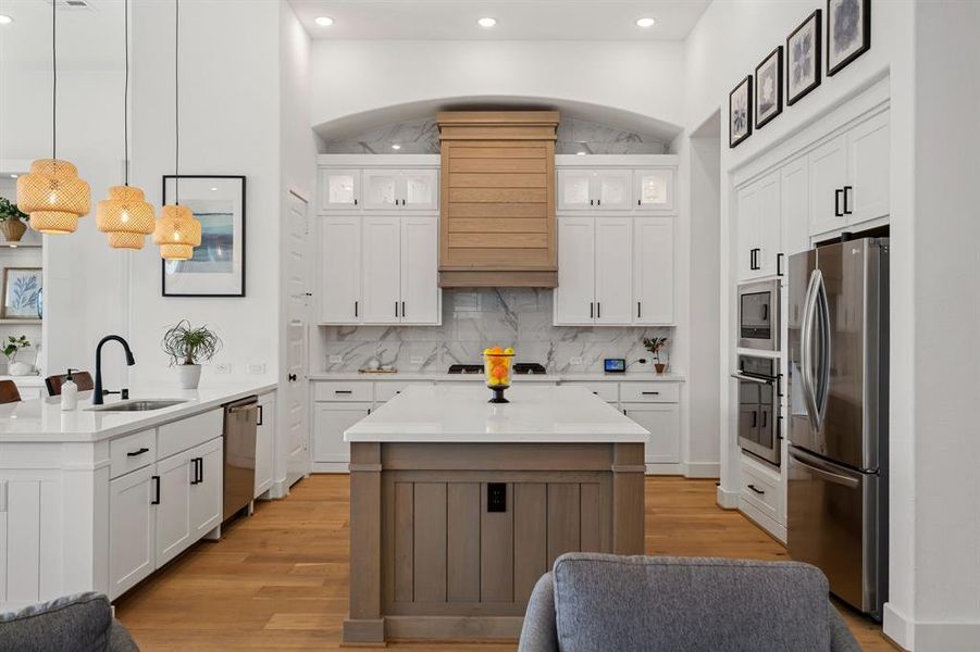 Quartz countertops, wicker pendants, stainless steel gas appliances, range stove top with a 5 burner stove, and built in oven and microwave make this kitchen ideal.