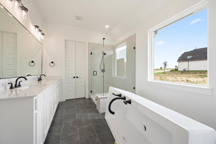 Bathroom with tile patterned floors, plus walk in shower, and double sink vanity