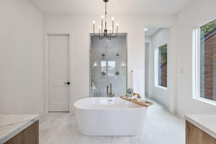 The primary bath is a true retreat with quartz, brass and white oak features.  The designer light fixture and beautiful standing tub are a perfect centerpiece to this light filled sanctuary.