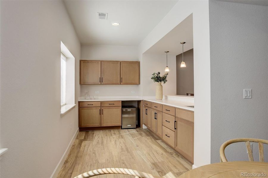 Basement wet bar with refrigerator and sink