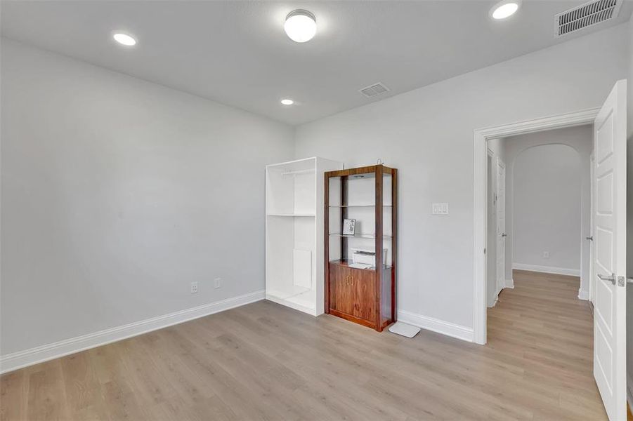 Unfurnished bedroom featuring light wood-type flooring, a closet, and a spacious closet