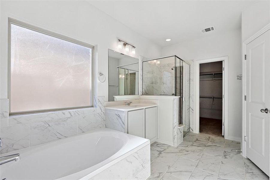 Bathroom with vanity, tile flooring, and shower with separate bathtub