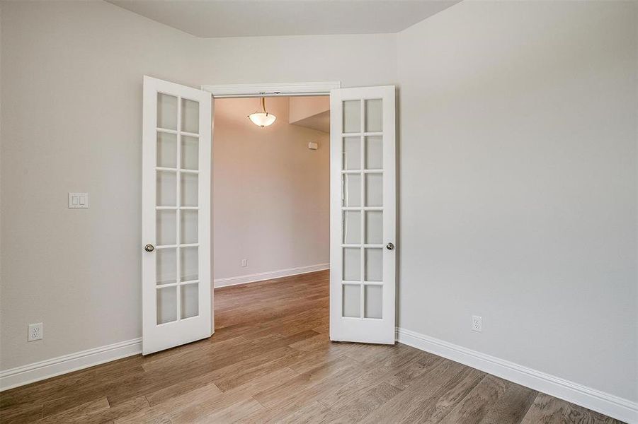 Unfurnished room with french doors and hardwood / wood-style floors