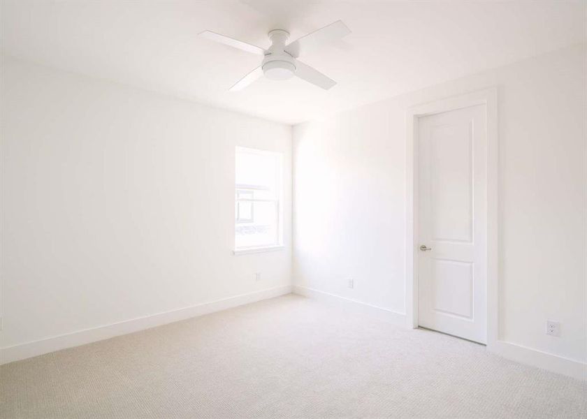 Carpeted spare room with ceiling fan