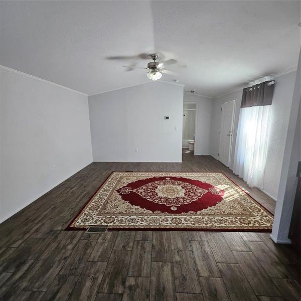 Unfurnished room featuring lofted ceiling, ceiling fan, dark hardwood / wood-style floors, and crown molding