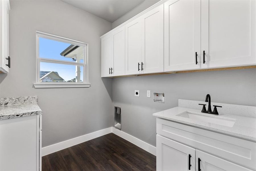 Laundry area featuring sink, cabinets, electric dryer hookup, dark hardwood / wood-style flooring, and hookup for a washing machine