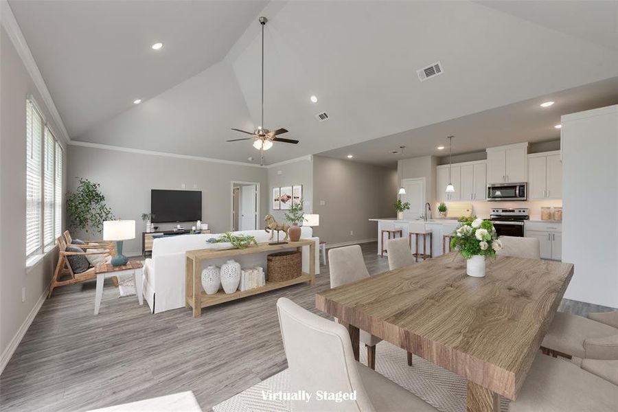 Dining room featuring crown molding, light hardwood / wood-style flooring, high vaulted ceiling, and ceiling fan