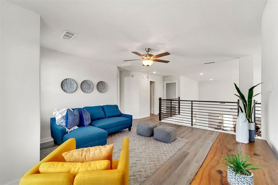 Living room featuring wood-type flooring and ceiling fan