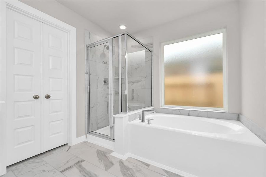 Enjoy a walk-in shower with tile surround, a separate garden tub with custom detailing.