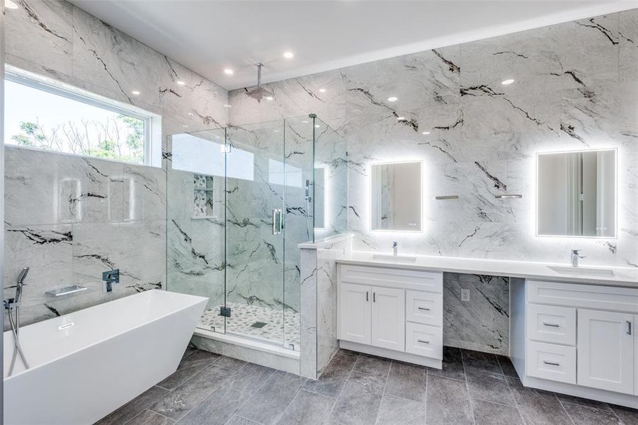 Bathroom with tile floors, dual vanity, plus walk in shower, and tile walls