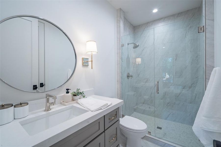 Bathroom featuring vanity, toilet, and walk in shower