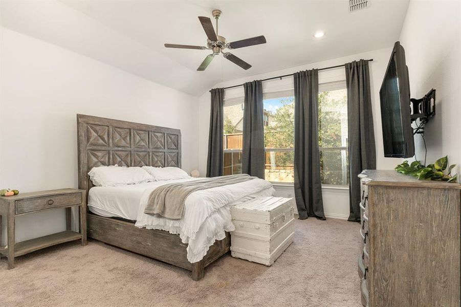 Bedroom featuring lofted ceiling, light carpet, and ceiling fan