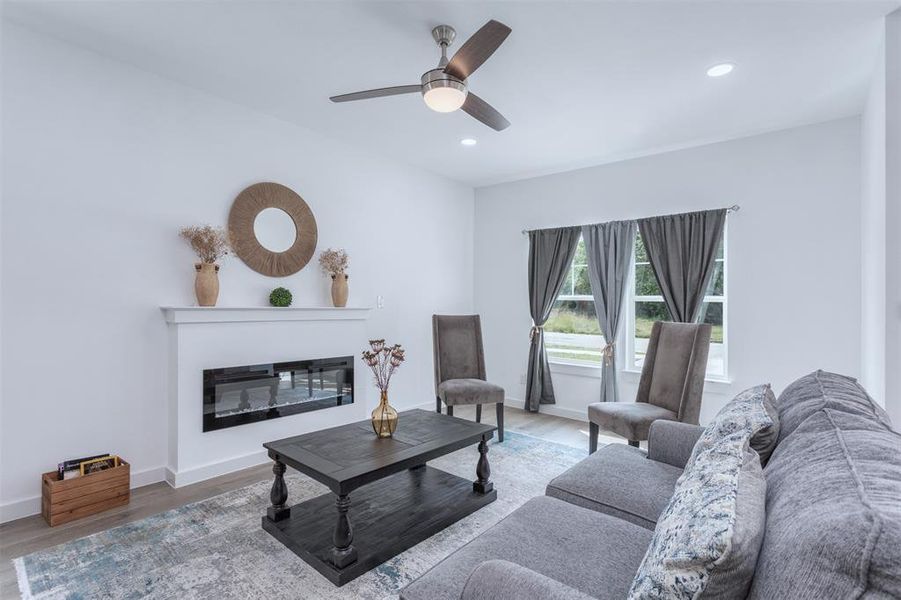 Living room featuring wood-type flooring and ceiling fan