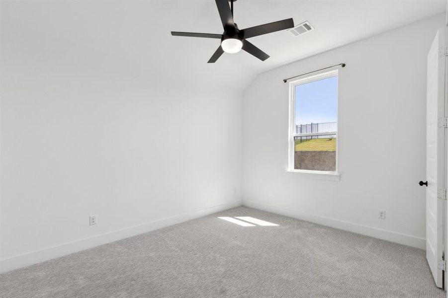 Unfurnished room featuring light carpet, vaulted ceiling, and ceiling fan