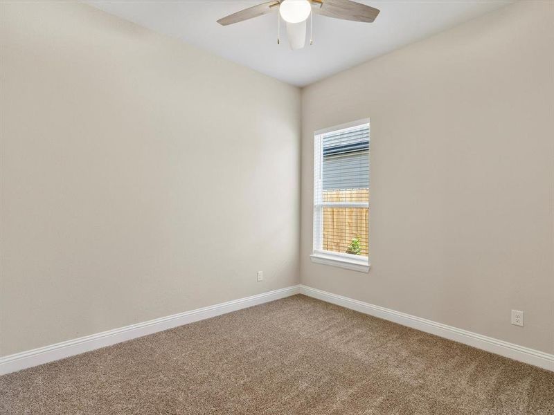 Empty room featuring ceiling fan and carpet flooring