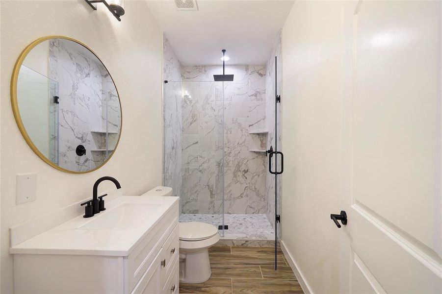 Guest bath on the second floor with seamless glass shower enclosure with rain head shower.