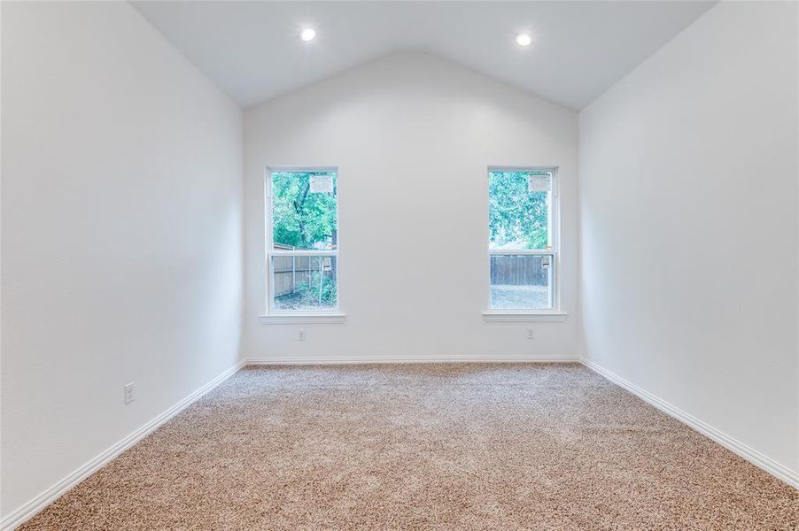 Spare room with lofted ceiling and light carpet