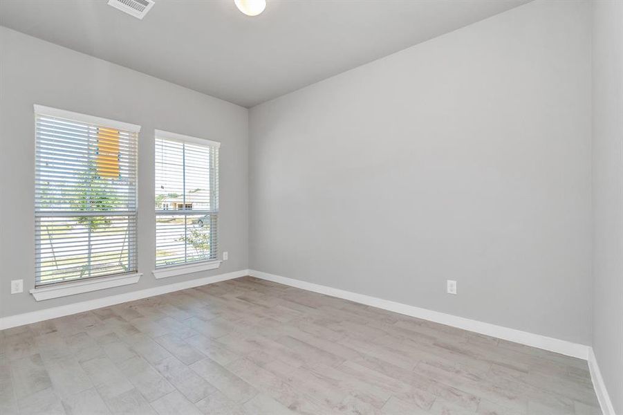 Another view of the home office with large windows for natural light. Sample photo of completed home with similar floor plan. As-built interior colors and selections may vary