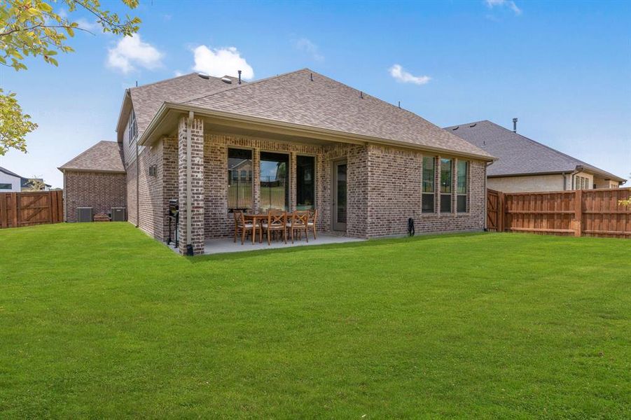 Rear view of property with central air condition unit, a patio area, and a yard