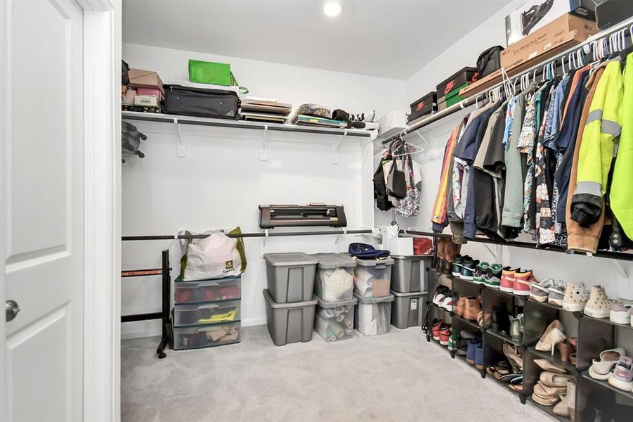 Primary walk in closet with direct access to laundry room