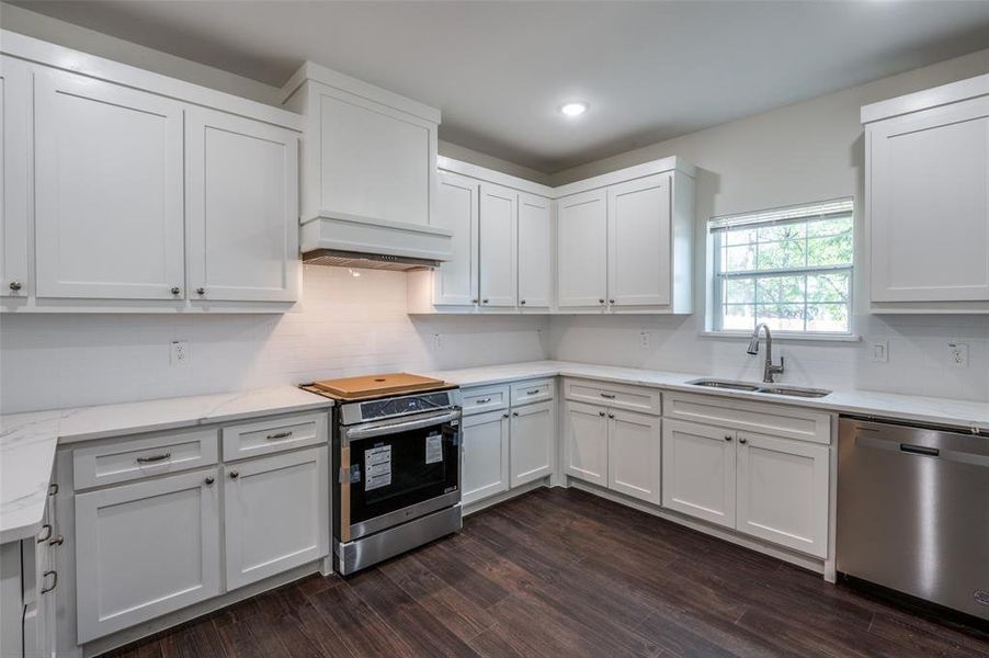 Kitchen featuring white cabinetry, stainless steel appliances, sink, and dark hardwood / wood-style flooring