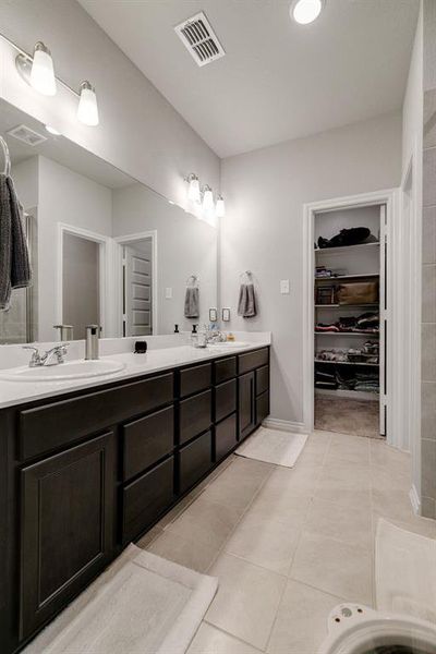 Bathroom with dual vanity and tile patterned flooring