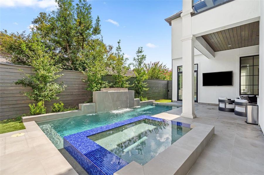 The magnificent pool with a sleek, modern design, is accompanied by a raised water feature that adds an extra touch of elegance.