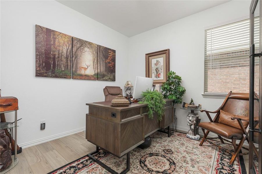 Home office with light hardwood / wood-style flooring