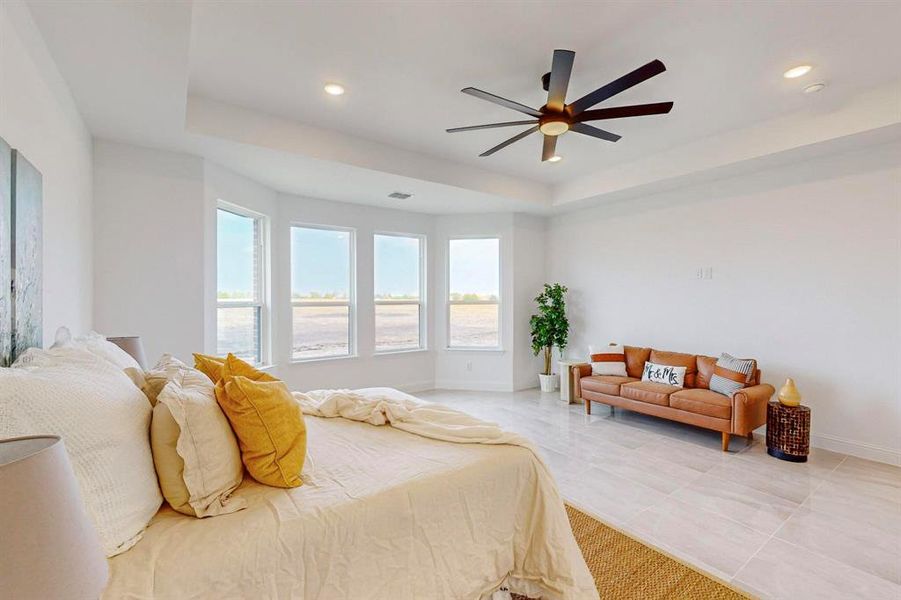 Bedroom featuring ceiling fan and a raised ceiling