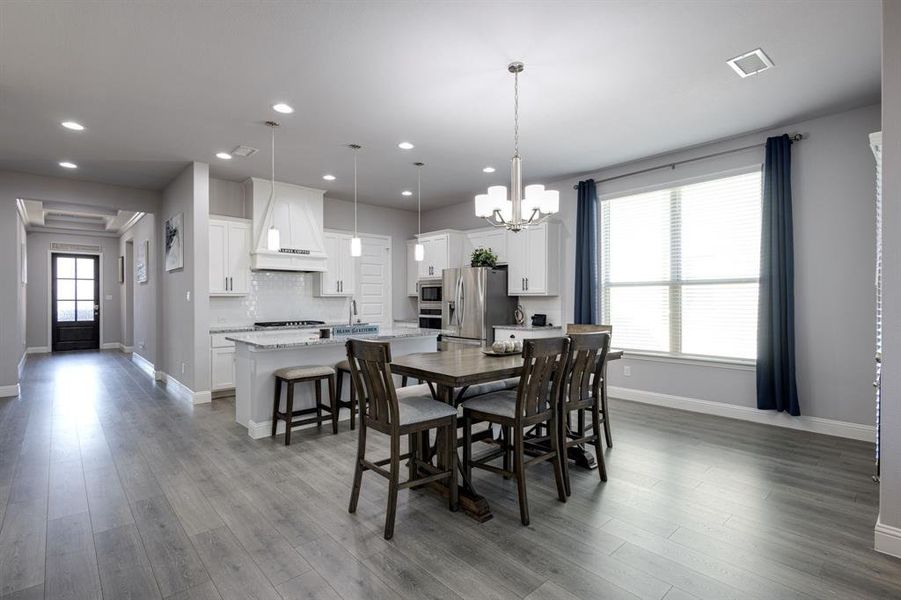 Dining area featuring an inviting chandelier and hardwood / wood-style flooring