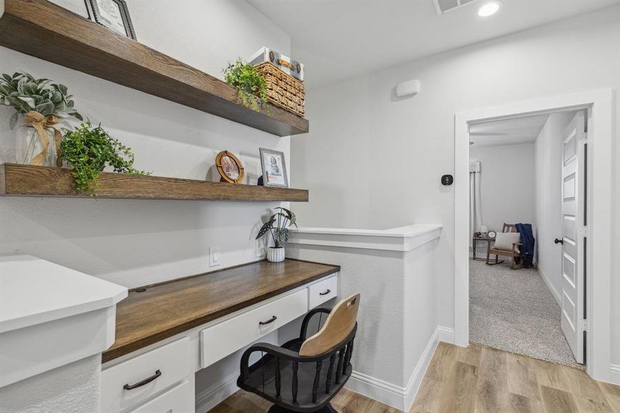 Carpeted home office with built in desk