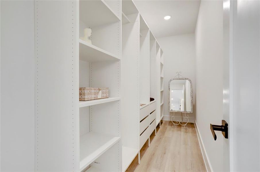 The spacious primary closet has custom built-in shelves and drawers.