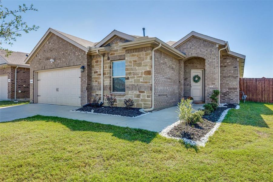 Ranch-style house with a garage and a front lawn