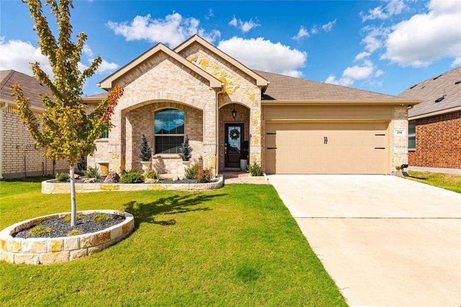 View of front of house featuring a front yard and a garage