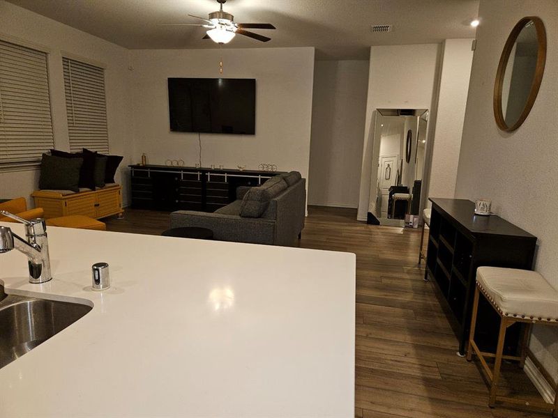 Living room with ceiling fan and dark hardwood / wood-style flooring