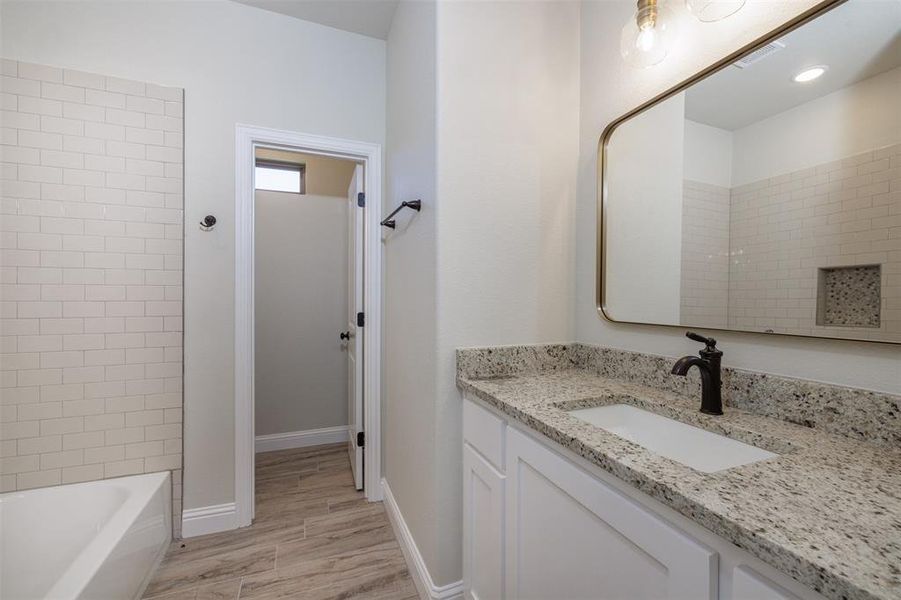 Bathroom featuring hardwood / wood-style flooring and vanity