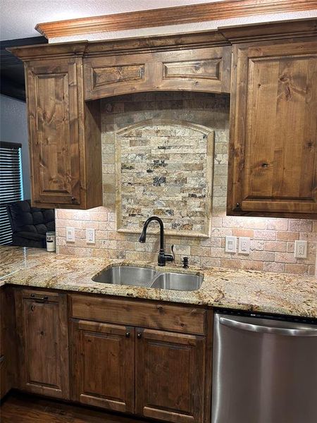 Kitchen featuring sink, dishwasher, dark brown cabinetry, and backsplash