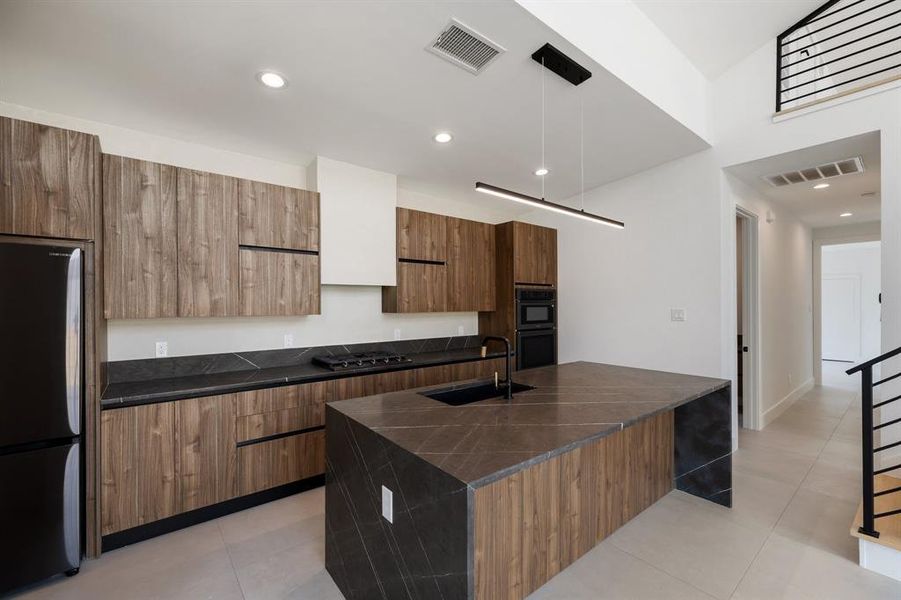 chef's kitchen featuring waterfall natural stone countertops, Italian-inspired cabinetry.