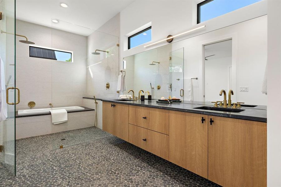 Large primary bathroom with dual vanity walk in shower and built in tub.