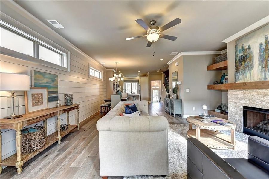 Living room with a fireplace, plenty of natural light, light wood-type flooring, and ceiling fan  ***Photos NOT OF ACTUAL Home but for representation Purposes only. Home is UNDER Construction- Photos are of a previously built Model House Freemont plan by