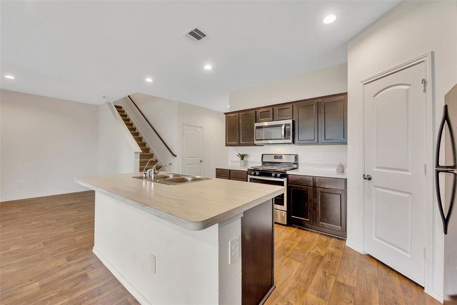 The island with the sink facing the windows and the living room allows you to enjoy the backyard, keep an eye on the kids, or watch TV while working in the kitchen.