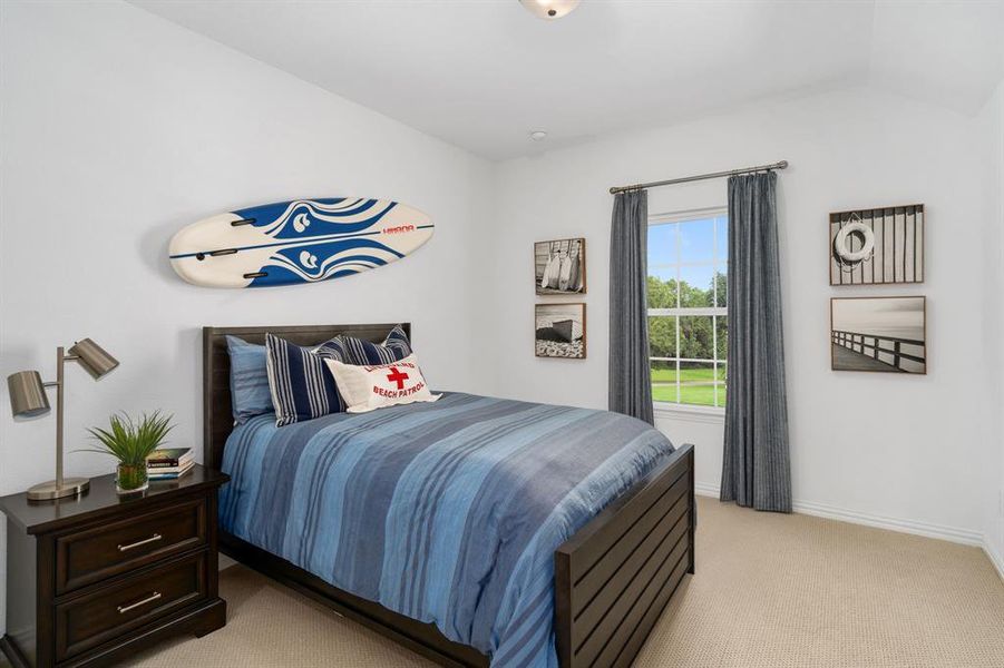 Carpeted bedroom featuring vaulted ceiling