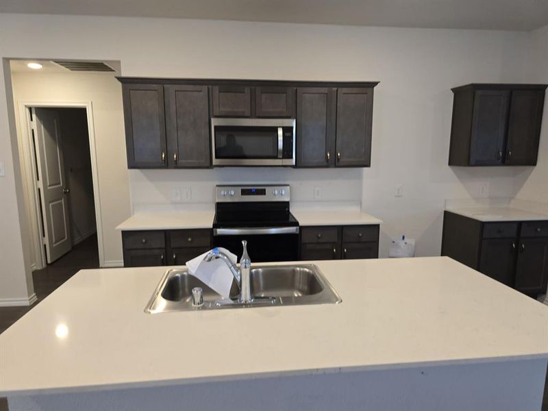 Kitchen featuring stainless steel appliances, a kitchen island with sink, and sink