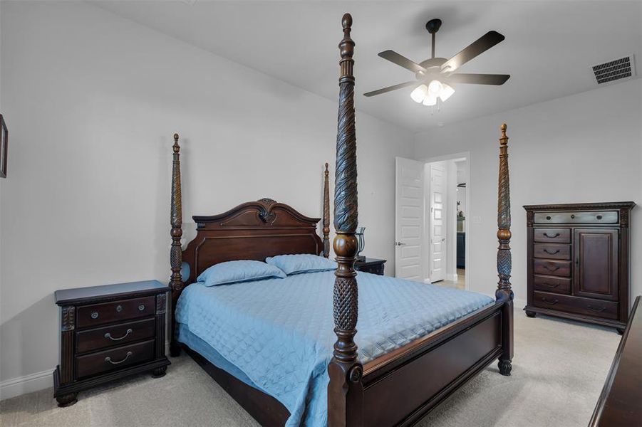 Carpeted bedroom featuring ceiling fan