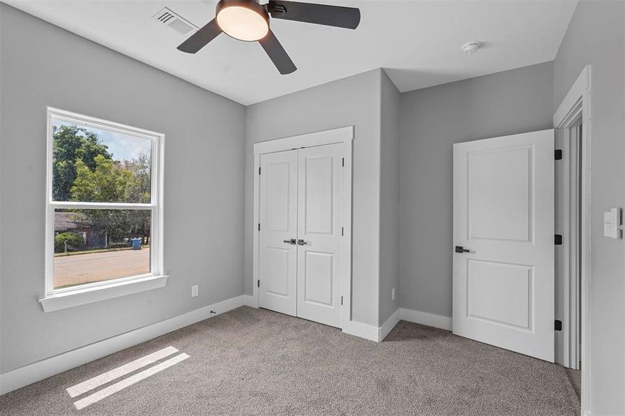 Unfurnished bedroom featuring a closet, ceiling fan, and light carpet