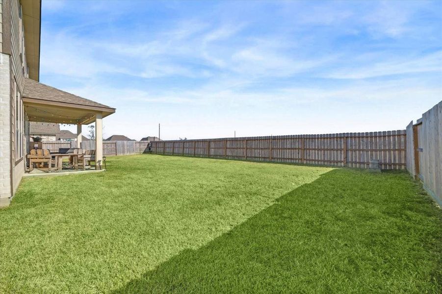 Expansive backyard with plenty of room for outdoor activities, fully fenced for privacy and security—perfect for pets or play.