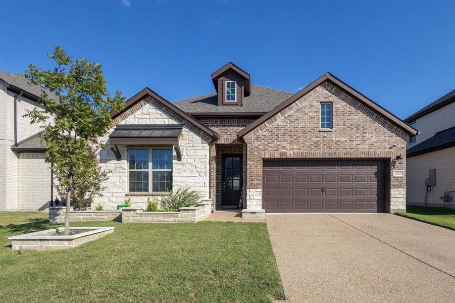 View of front of home featuring a garage and a front lawn