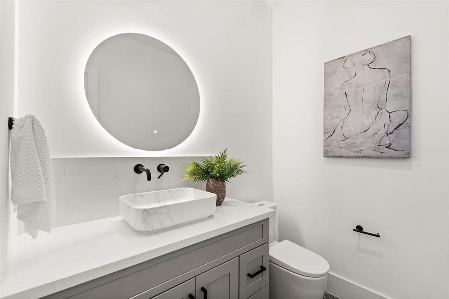 A Half Bath great for guests with exquisite sink, finishes and circle mirror!