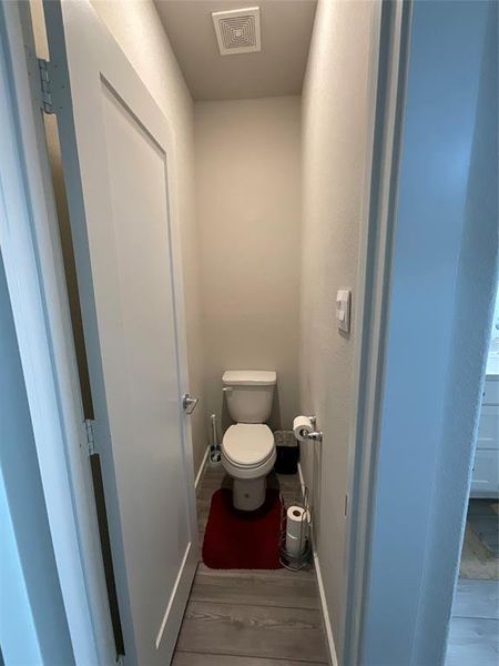 Bathroom with hardwood / wood-style flooring and toilet