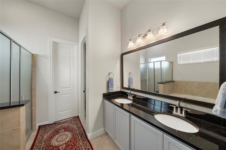 Bathroom featuring vanity, a bathtub, and tile patterned floors